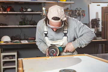 Male carpenter working on old wood in a retro vintage workshop.