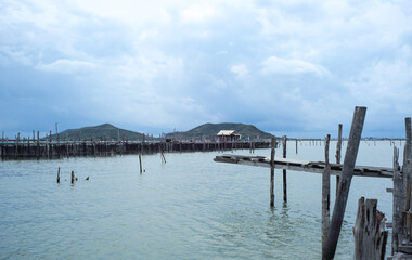 Native fisherman house and traditional fishing farm at the coast of sea with old wooden walkway