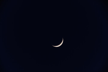 Young Moon and Venus on a dark night sky.