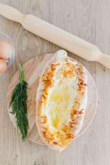 Khachapuri in Adjarian. Open pie with cheese and egg. Georgian cuisine.