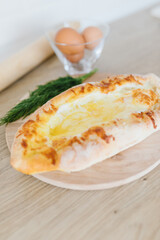 Khachapuri in Adjarian. Open pie with cheese and egg. Georgian cuisine.