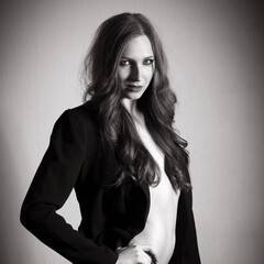 Fashion portrait of an attractive woman wearing black coat, monochrome photo