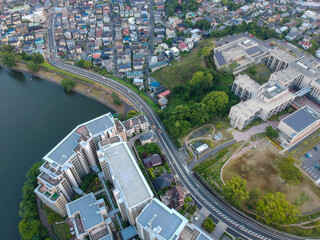 航空撮影した夕方の街風景と公園の池