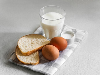 Breakfast ingredients. Still life of eggs, milk and bread on a white background. Close-up