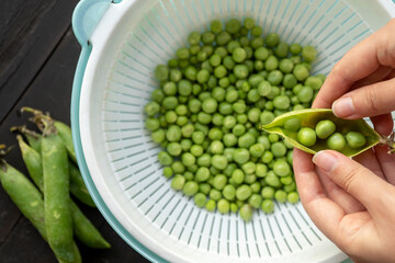hand holding green peas