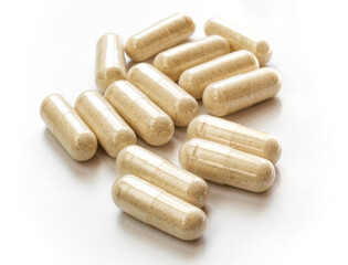 Group of brown capsules spilled on white 