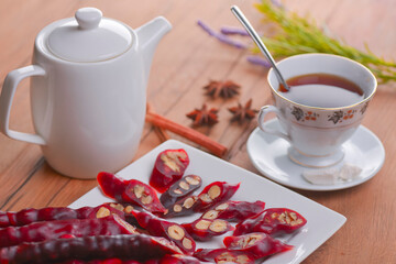 Tasty oriental sweets. Caucasian delicacy churchkhela - georgian nut treats. Served with a glass of tea and a tea pot.
