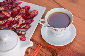 Tasty oriental sweets. Caucasian delicacy churchkhela - georgian nut treats. Served with a glass of tea and a tea pot.