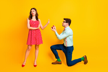 Full length photo of frustrated girl reject guy give her jewelry ring propose marry wear red dotted...
