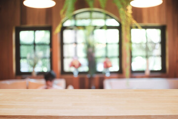 Empty wooden desk space platform and blurred restaurant or coffee shop background for product display montage.