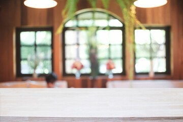 Empty wooden desk space platform and blurred restaurant or coffee shop background for product display montage.