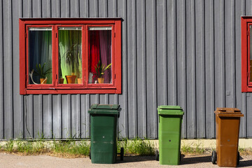 Jokkmokk, Sweden  Three garbage cans reflect three window panes on a building on the main street.