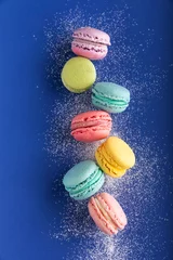 Foto op Canvas stilleven kleurrijke macarons op blauwe achtergrond met suiker © simonasbrilli
