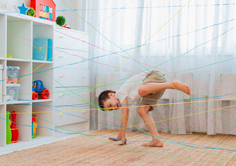 boy brother, siblings, friendschild climbs through a rope web, a game obstacle quest indoors.