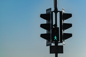 Street traffic light on which the permission signal for pedestrians is lit.