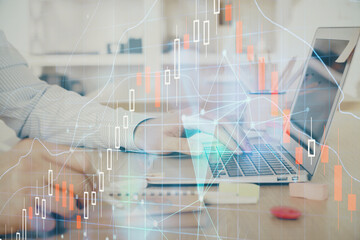 Multi exposure of stock market graph with man working on laptop on background. Concept of financial analysis.
