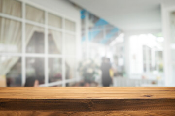 Empty wooden table space platform and blurred restaurant or coffee shop background for product display montage.