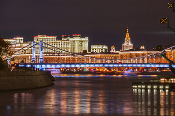 Fototapeta na wymiar Illuminated Moscow bridge across the Moskva river at evening or night with city lights.