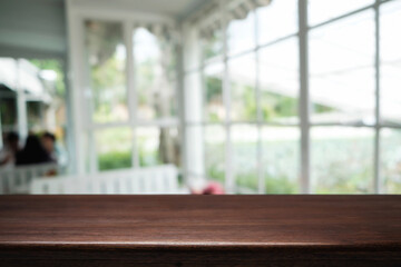 Empty wooden table space platform and blurred restaurant or coffee shop background for product display montage.