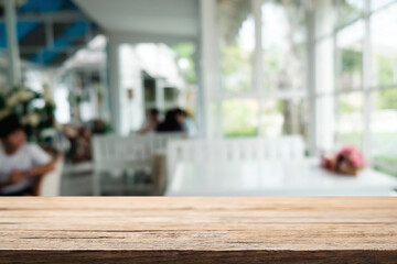 Empty wooden table space platform and blurred restaurant or coffee shop background for product display montage.