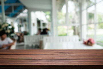 Empty wooden table space platform and blurred restaurant or coffee shop background for product display montage.