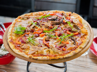 Ready pizza on a wooden plate. Selective focus.