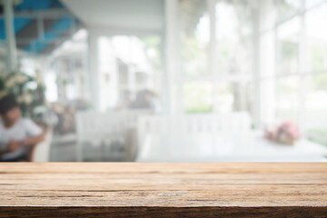 Wooden desk space platform and blurred restaurant or coffee shop background for product display montage.