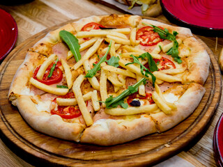 Ready pizza on a wooden plate. Selective focus.