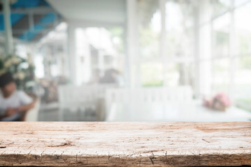 Wooden desk space platform and blurred restaurant or coffee shop background for product display montage.
