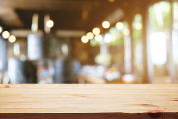 Empty wooden table space platform and blurred restaurant or coffee shop background for product display montage.