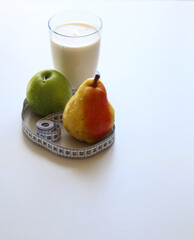 a glass of kefir, ripe apple and pear on a white background close up