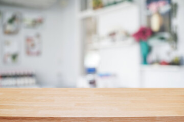 Empty wooden desk space platform over blurred restaurant or coffee shop background for product display montage.