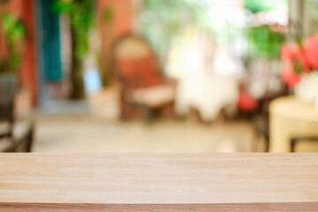 Empty wooden table space platform and blurred restaurant or coffee shop background for product display montage.