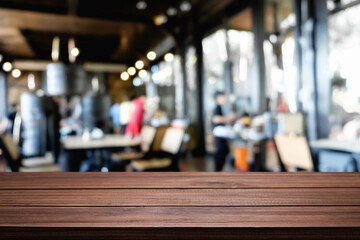 Empty wooden desk space platform over blurred restaurant or coffee shop background for product display montage.