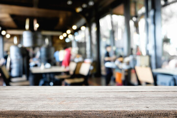Empty wooden desk space platform over blurred restaurant or coffee shop background for product display montage.
