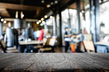 Empty wooden desk space platform over blurred restaurant or coffee shop background for product display montage.