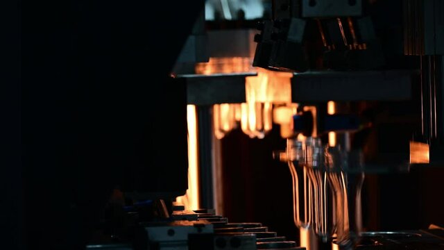 The tube preform shape of bottles preheat process on the production line to the automatic blowing machine. The operation of PET bottle processing by blowing process with the blowing mold. 