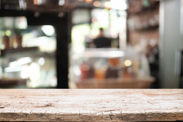 Empty wooden desk space platform over blurred restaurant or coffee shop background for product display montage.