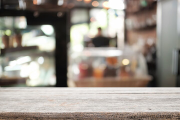 Empty wooden desk space platform over blurred restaurant or coffee shop background for product display montage.