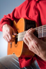 Fototapeta na wymiar Fingers of a guitar player playing acoustic guitar.