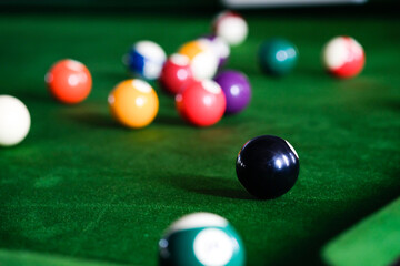 Man's hand and Cue arm playing snooker game or preparing aiming to shoot pool balls on a green billiard table. Colorful snooker balls on green frieze.