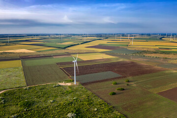 Aerial view at fields and wind turbine farms. Horizontal view