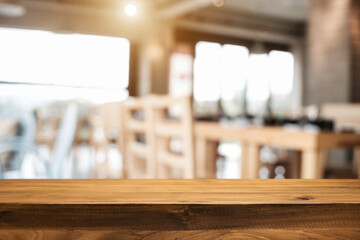 Empty wooden desk space platform with blur restaurant or coffee shop background for product display montage.
