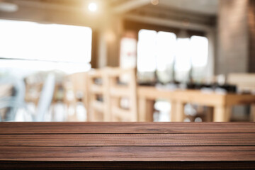 Empty wooden desk space platform with blur restaurant or coffee shop background for product display montage.