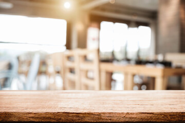 Empty wooden desk space platform with blur restaurant or coffee shop background for product display montage.