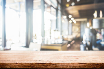 Fototapeta premium Empty wooden table space platform and blurred resturant or coffee shop background for product display montage.