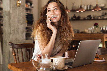 Beautiful young smiling girl sitting at the kitchen table