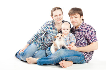 family in checkered shirts with baby daughter and small dog.