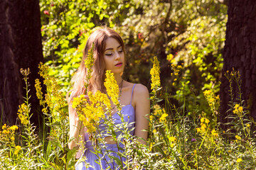 The girl is sitting in the thick grass.