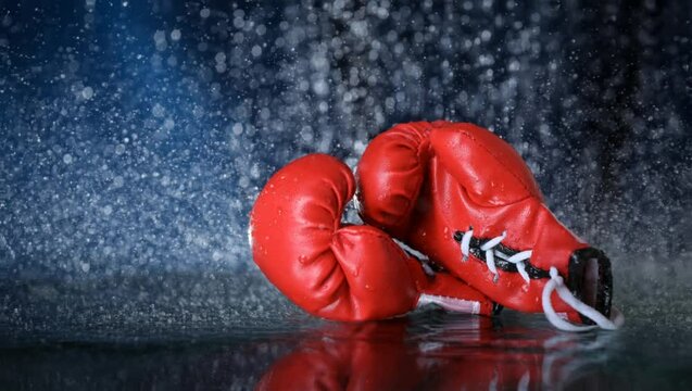 Cinemagraph of red boxing gloves on a water drops background. Sport lifestyle. Motivation. Goal achievement. Protect yourself. Motion photography	
